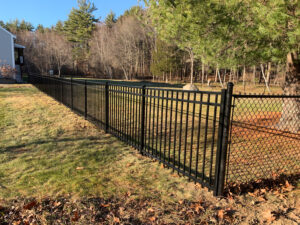 a newly installed aluminum and chain link fence on a residential property